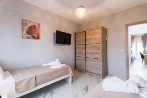 um quarto com uma cama e uma televisão na parede em Zeusplace Pieria Luxury Apartment em Kateríni