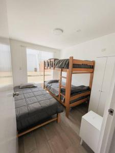 a room with two bunk beds and a window at SOLARIUM CHINCHA Casa de Campo y Playa de 1000mts! in Sunampe