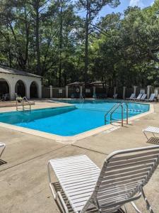 a large swimming pool with chairs at Peaceful Relaxation and Comfort in Hilton Head Island