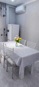 a white table with chairs and a white refrigerator at Жк K7 Family 1-комнатная in Atyraū
