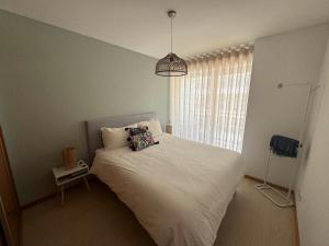 a bedroom with a white bed and a window at Apartamento Lux 1882 in Figueira da Foz