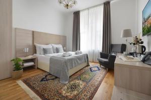 a bedroom with a bed and a couch and a chair at Prague Old Town Residence in Prague