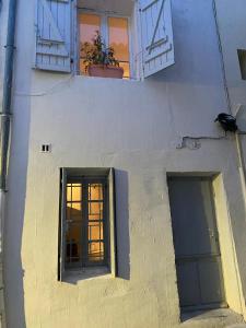 un edificio blanco con dos ventanas y una puerta en SoeursGrises Béziers Centre Historique coeur de l'Hérault capitale d'Occitanie, en Béziers