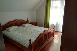 1 dormitorio con cama de madera y ventana en Wczasy u Ireny, en Lubiatowo