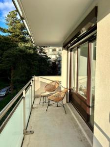 un balcón con 2 sillas y una mesa. en Flat 4 people St Julien NEAR GENEVA en Saint-Julien-en-Genevois