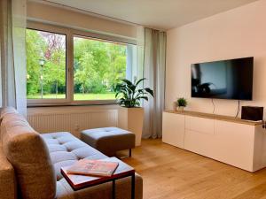 a living room with a couch and a tv at Leo‘s MUNICH Apartment in Munich
