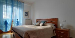 Appartamento Perugia - Casa Penelope في بيروجيا: غرفة نوم بسرير ونافذة ذات ستائر زرقاء