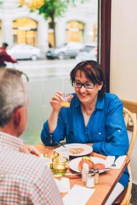a woman sitting at a table drinking from a glass at Crystal Plaza Hotel in Stockholm