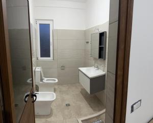 bagno con 2 servizi igienici e lavandino di Stone Villa Shengjin a Shëngjin