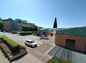Appartamento Perugia - Casa Penelope في بيروجيا: موقف للسيارات مع سيارتين متوقفة أمام مبنى