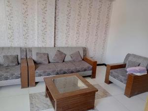 a living room with a couch and a coffee table at Murree Apartments in Murree