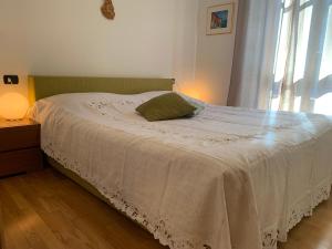 a bedroom with a bed with a white blanket and a window at VECCHIA STAZIONE - by Satisfactual Property in Menaggio