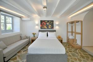 a bedroom with a large bed and a couch at Douskos Citrus Apartments in Hydra