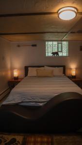 1 dormitorio con 1 cama con 2 lámparas y una ventana en Escape in our Rain-Forest A-Frame Cabin-Retreat 1hour from The Pononos, en Harveys Lake