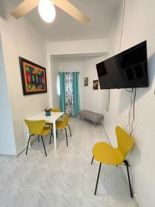 a living room with a table and chairs and a tv at YOUR SPACE COLONIAL in Santo Domingo