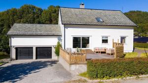 a white house with a patio and a couch at Aalesund Holiday Home 5 Bedroom! in Ålesund