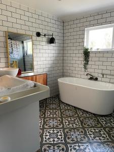 y baño con bañera, lavabo y espejo. en Aalesund Holiday Home 5 Bedroom! en Ålesund