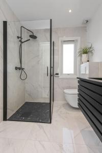 a bathroom with a shower with a glass door at Aalesund Holiday Home 5 Bedroom! in Ålesund