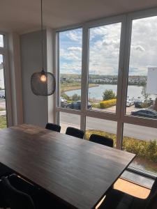 a table and chairs in a room with a large window at Haus mit Panoramablick auf den Phönixsee in Dortmund