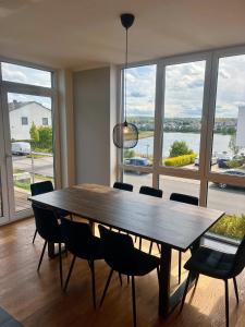 a dining room table with chairs and a large window at Haus mit Panoramablick auf den Phönixsee in Dortmund