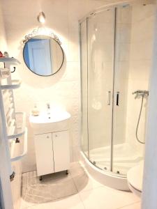 a bathroom with a shower and a sink and a mirror at Przy Plaży in Karwia +34 photos