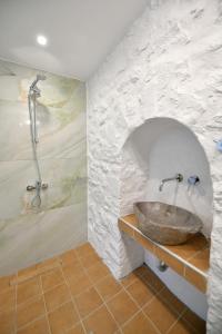 a bathroom with a stone sink and a shower at Douskos Citrus Apartments in Hydra