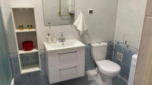 a bathroom with a white toilet and a sink at Apartament 35 in Zamość