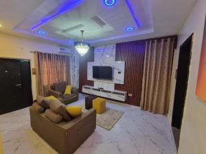 a living room with a couch and a television at Mirola Apartments in Ilorin