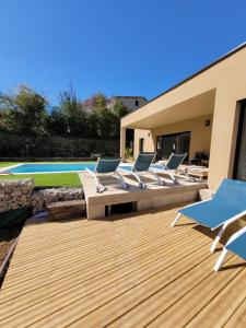 a deck with lounge chairs and a swimming pool at Maison des libellules de dugradus in Aubenas