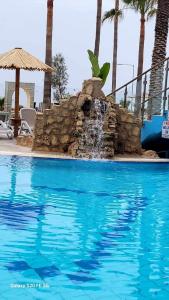 a swimming pool with a fountain in a resort at Simos Magic Beach Hotel Apts in Ayia Napa