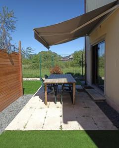 a patio with a table and a patio umbrella at Mini Apartamento de 30 mts en Chaves in Chaves