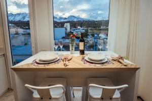 a table with a bottle of wine and a window at Original House Hotel Boutique in Ushuaia