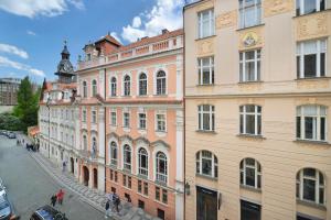 ein Gebäude mit einem Uhrturm neben einer Straße in der Unterkunft Prague Old Town Residence in Prag