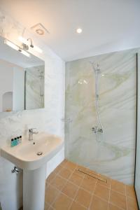 un baño con lavabo y ducha en Douskos Citrus Apartments, en Hydra