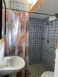 a bathroom with a shower with a sink and a toilet at Hotel House Hoskins Talara- con AIRE ACONDICIONADO, uso de cocina in Talara