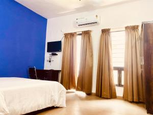 Separate 2 AC Rooms Kalyani Nagar Near Pune Airport Osho Garden WTC في بيون: غرفة نوم بسرير ونافذة مع ستائر