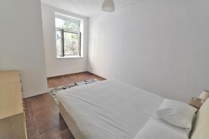 ein Schlafzimmer mit einem weißen Bett und einem Fenster in der Unterkunft Mariahilf Apartment in Wien