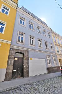 ein großes graues Gebäude mit einer Tür und einer Garage in der Unterkunft Mariahilf Apartment in Wien