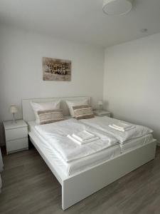 1 dormitorio blanco con 1 cama grande con sábanas y almohadas blancas en Gemütliche Ferienwohnung im Stadtzentrum mit wundervollem Blick, en Bremerhaven 17 fotos más