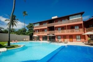 una gran piscina frente a un edificio en Pousada Un Paso del Mar en Porto De Galinhas