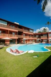 a large building with a swimming pool in front of it at Pousada Un Paso del Mar in Porto De Galinhas