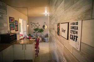 a kitchen with a counter and a room with a table at Casa Areal,1 Suíte, 2 Quartos Climatizados, piscina e Estacionamento 2 carros in Pelotas
