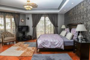 a bedroom with a bed and a tv and curtains at Villa Al Mansouria in Cairo
