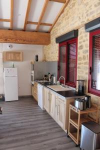 eine Küche mit einer Spüle und einem Kühlschrank in der Unterkunft Gite Le marronnier - Parthenay - 10 personnes - Gite à la campagne à 3 kms du centre-ville in Parthenay