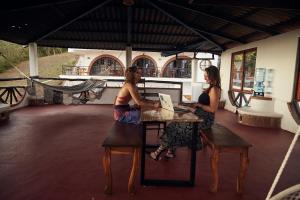 Deux femmes assises à une table dans un bâtiment dans l'établissement Beachside stay at Villa ViYarte, à San Juan del Sur