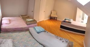 ein Wohnzimmer mit 2 Betten und einem Stuhl in der Unterkunft Spacious Family Room in Pickering for 4-5 members-Great Location P2a in Pickering