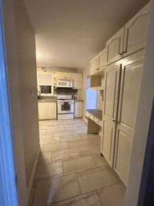 a kitchen with white cabinets and a tile floor at Spacious Family Room in Pickering for 4-5 members-Great Location P2a in Pickering