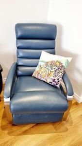 una sedia blu con cuscino in una stanza di Causeway97 Townhouse a Portrush