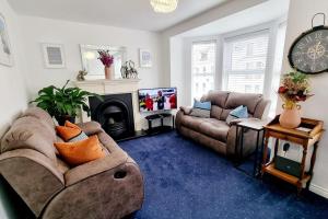 a living room with two couches and a fireplace at Causeway97 Townhouse in Portrush