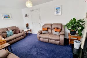 un soggiorno con 2 divani e un tappeto blu di Causeway97 Townhouse a Portrush